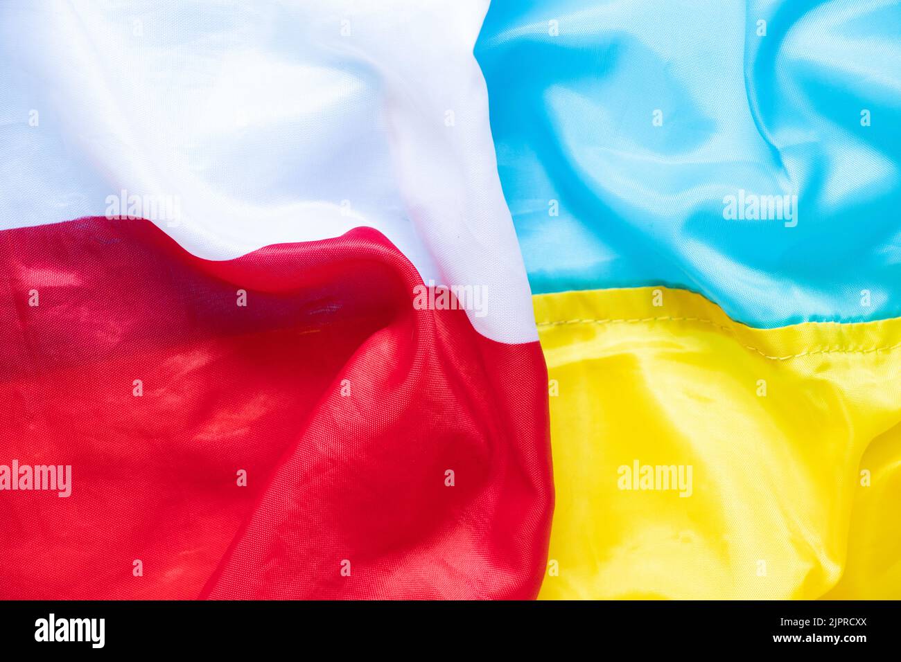 Die Flagge Polens und die Flagge der Ukraine als Hintergrund, ein Bündnis zwischen den beiden Ländern während des Krieges in der Ukraine Stockfoto
