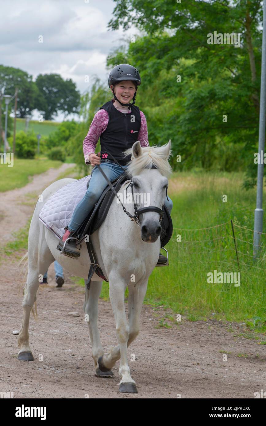 Lachendes Mädchen, 10 Jahre, auf einem Pferd, Mecklenburg-Vorpommern, Deutschland Stockfoto