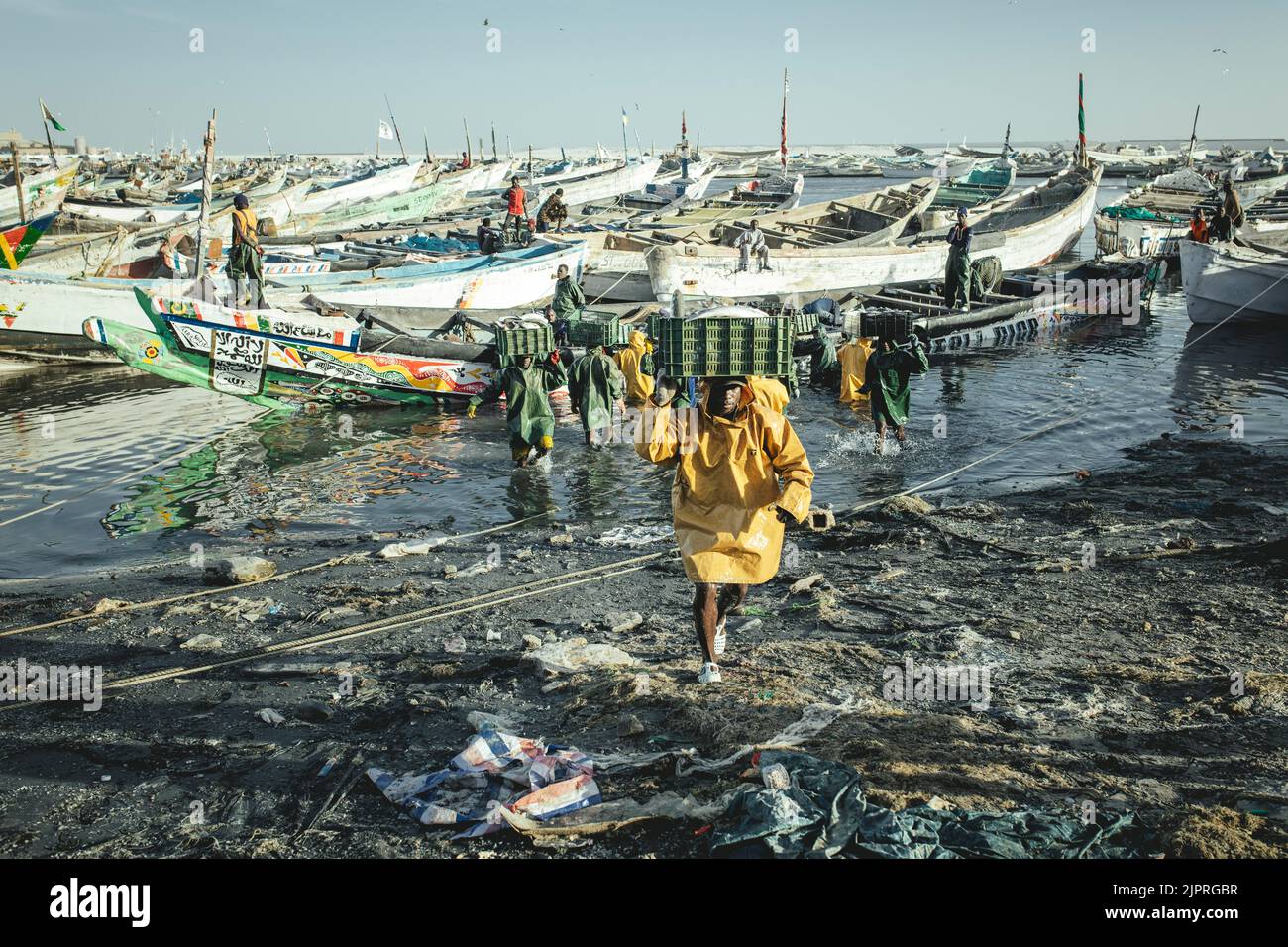 Ankunft der Fischer mit dem Fang des Tages im Hafen leeren große Trawler der Fischmehlfabriken das Meer vor der Küste, die Stockfoto