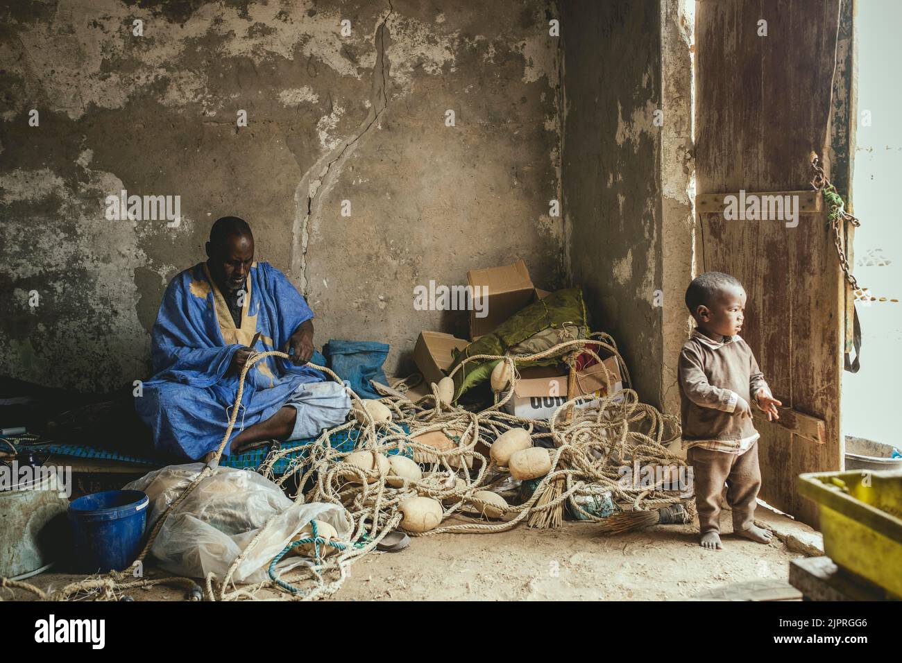 Fischer, die Netze ausbessern in Nouamghar, einem Fischerdorf am Atlantischen Ozean, in Nouamghar, Mauretanien Stockfoto
