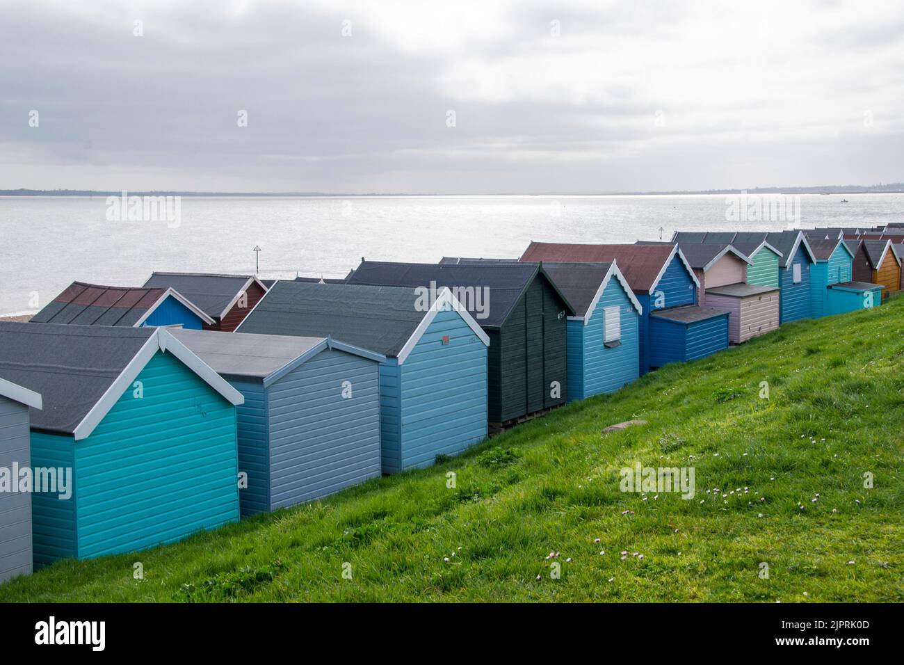 Blick von hinten auf eine Reihe von Strandhütten am Frinton on Sea in Essex UK Stockfoto