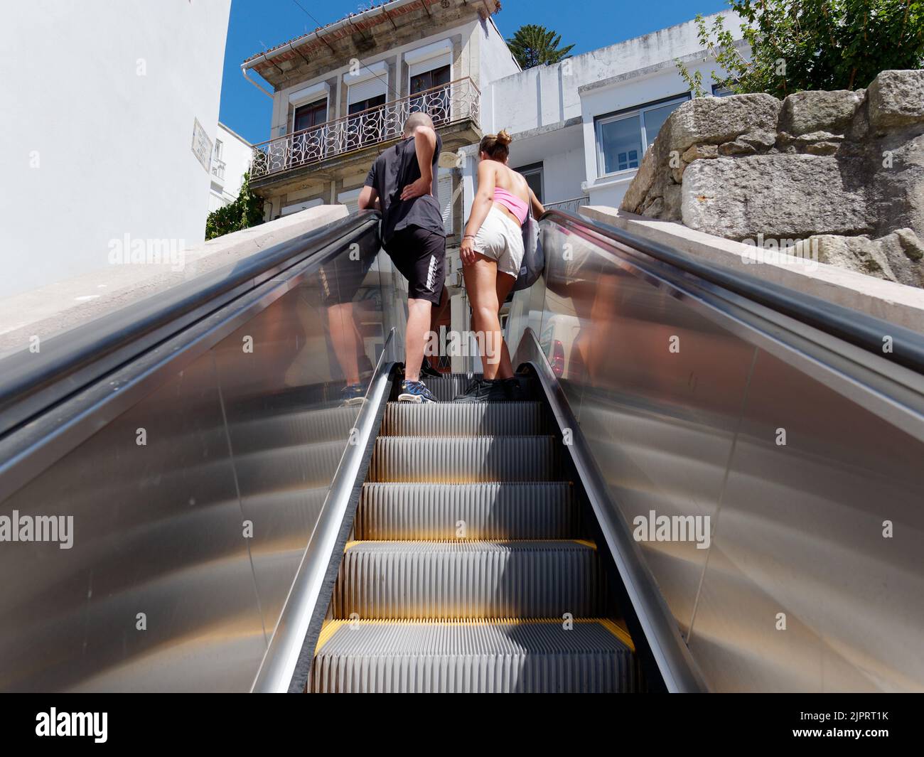 Ein junges Paar benutzt die Außenseiten-Rolltreppen in Porto, Portugal. Entwickelt, um Fußgängern bei der hügeligen Natur der Stadt zu helfen. Stockfoto