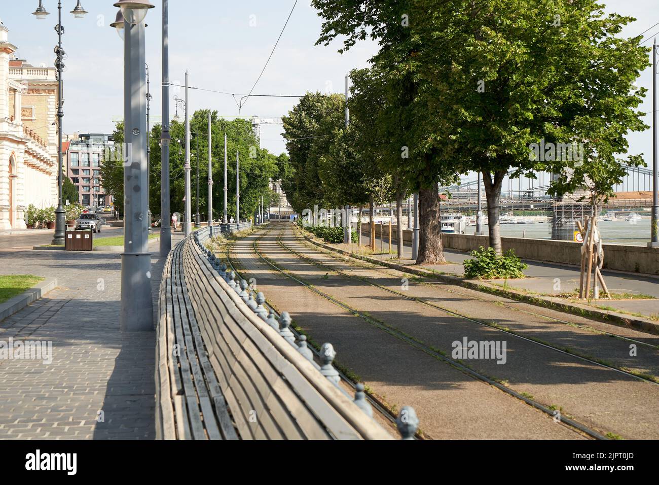 Blick auf die Straße auf die Bahnschienen und Bäume. Stockfoto