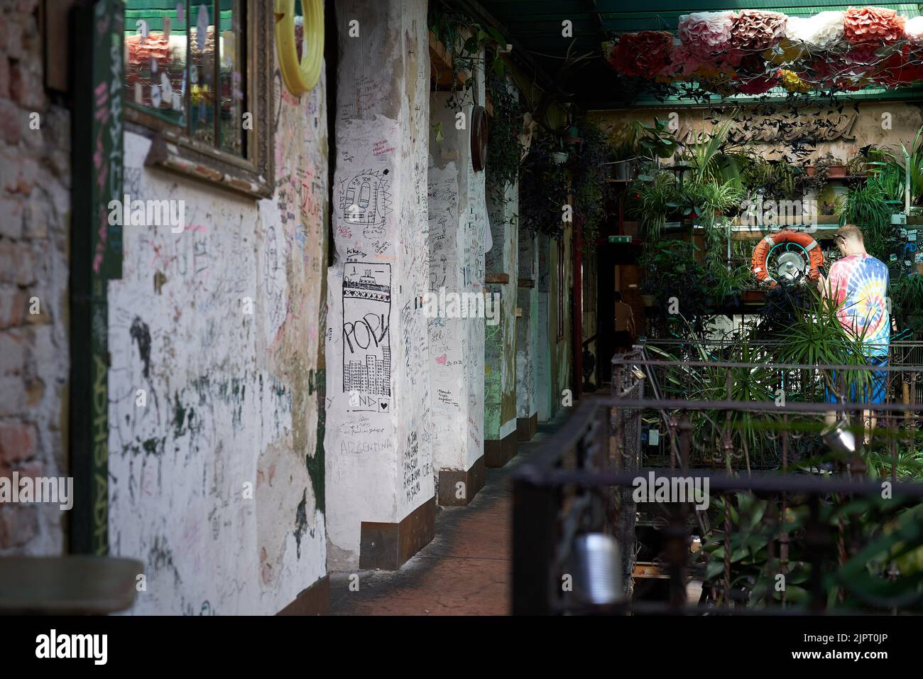 Ungarn, Budapest, Juli 20 2022. Männer gehen in die Budapester Pub-Ruinen im zweiten Stock. Stockfoto