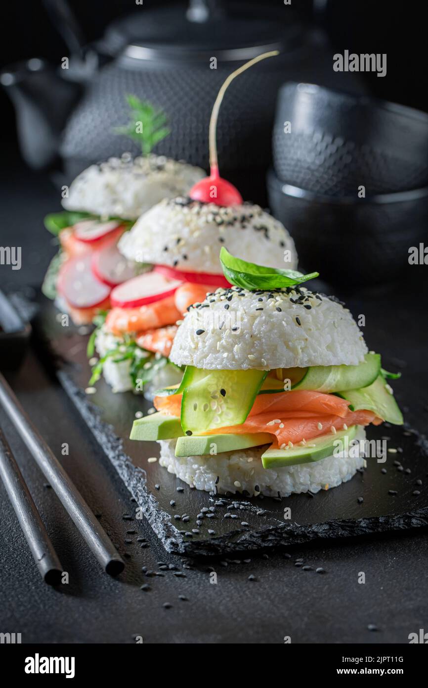 Einzigartiger und köstlicher Sushi-Burger mit Gemüse und Meeresfrüchten als japanische Vorspeisen. Sushi mit Meeresfrüchten, die auf einzigartige Weise zubereitet werden. Stockfoto