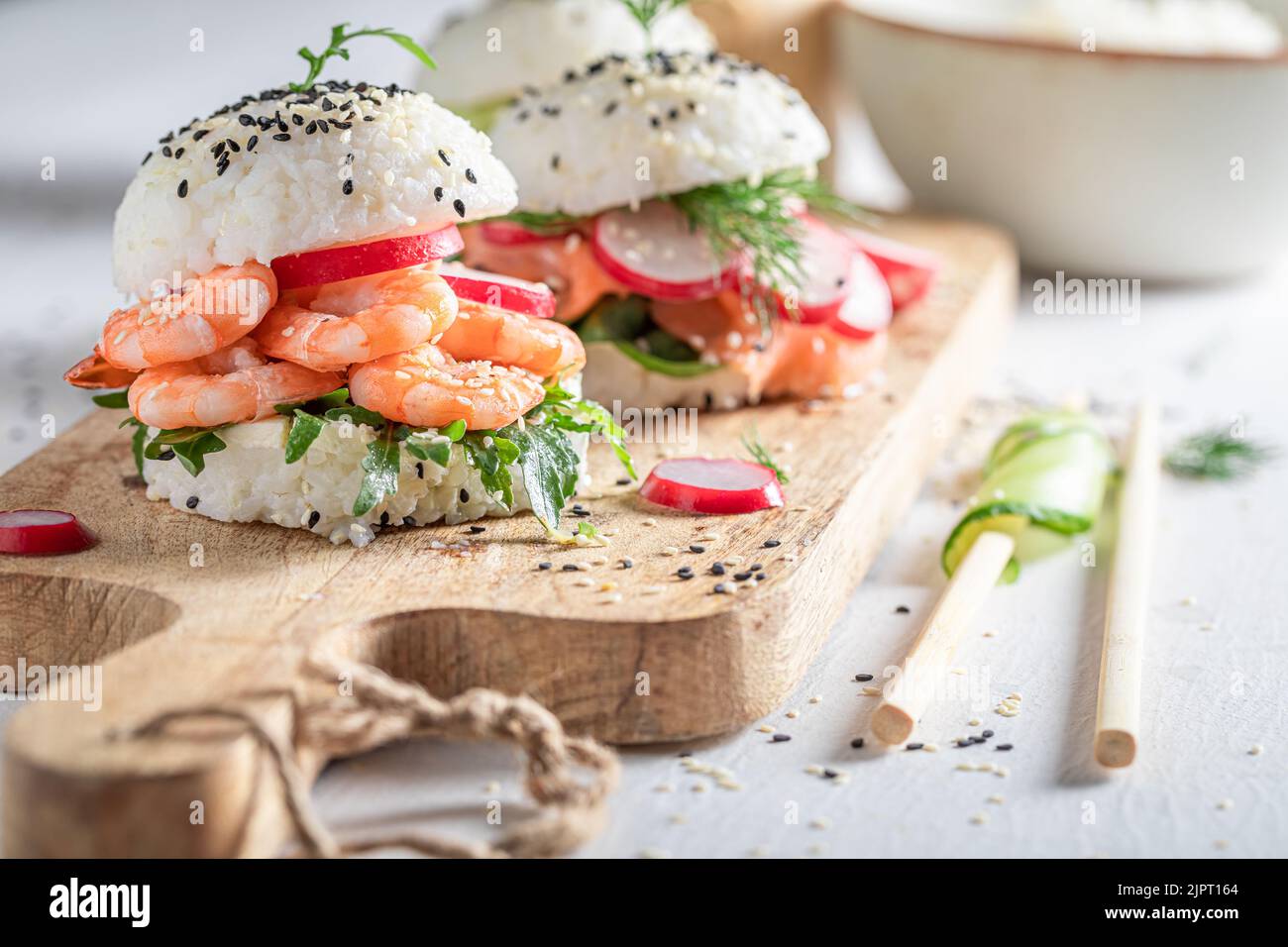 Köstlicher und exquisiter Sushi-Burger mit Avocado und Lachs als japanische Vorspeisen. Sushi mit Meeresfrüchten, die auf einzigartige Weise zubereitet werden. Stockfoto