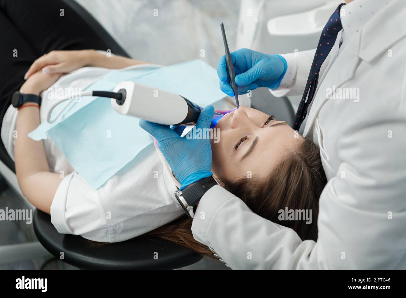 Nahaufnahme einer Patientin im Zahnarztstuhl bei einem Verfahren der intraoralen digitalen Untersuchung ihrer Zähne. Moderner 3D Dental-Scanner Stockfoto