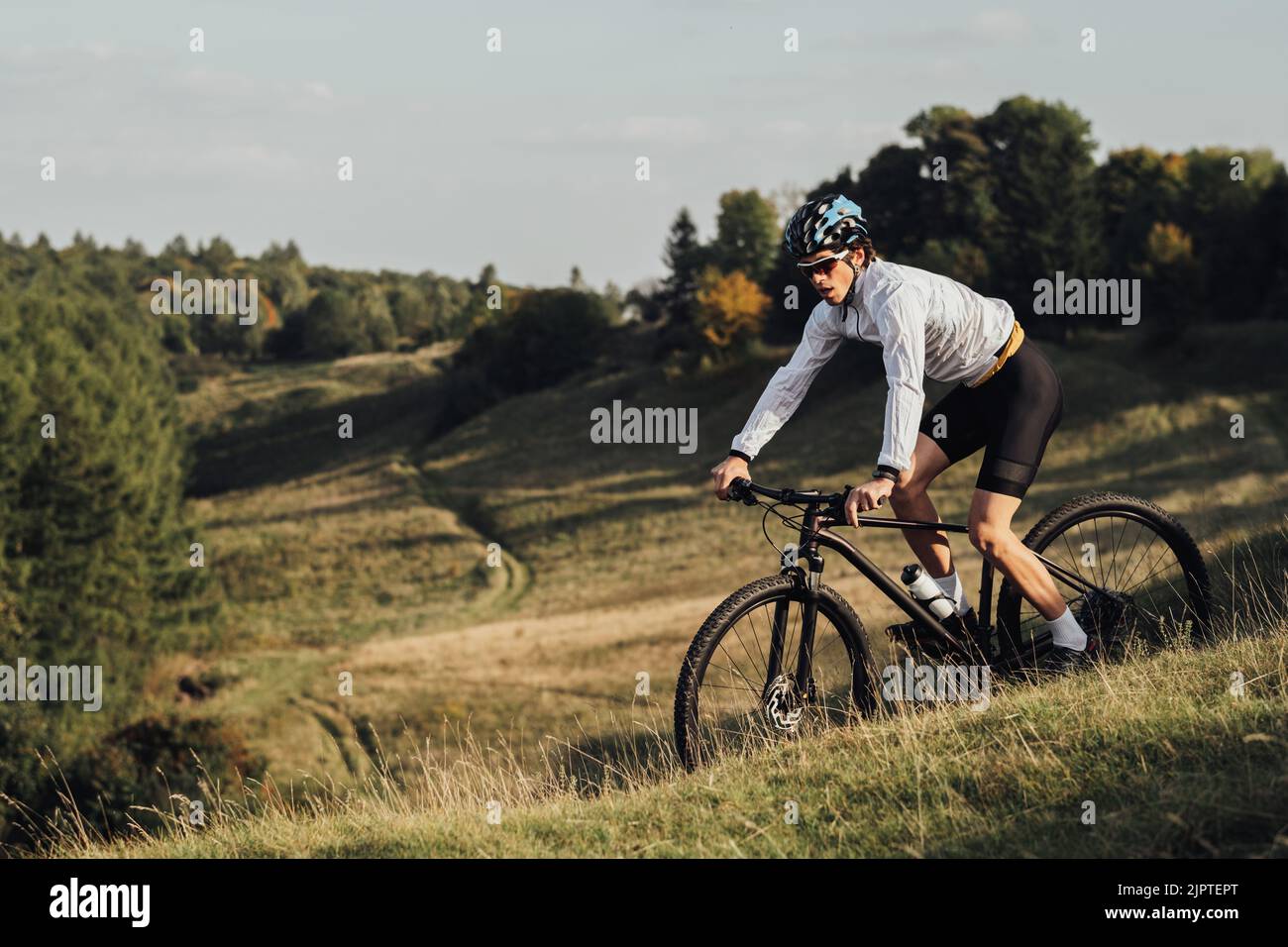 Professioneller Radsportler im Freien, ausgerüsteter Erwachsener auf dem Fahrrad auf dem Trail, Kopierraum Stockfoto