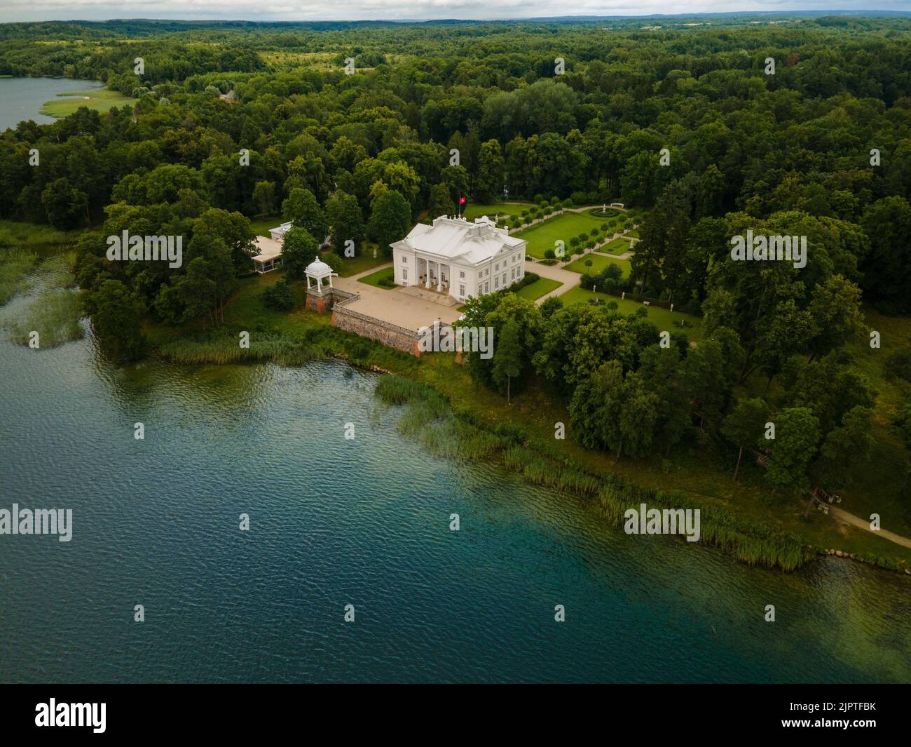 Eine Luftaufnahme des Herrenhauses Uzutrakis am Galvensee in Trakai, Litauen, mit grünen Bäumen im Hintergrund Stockfoto