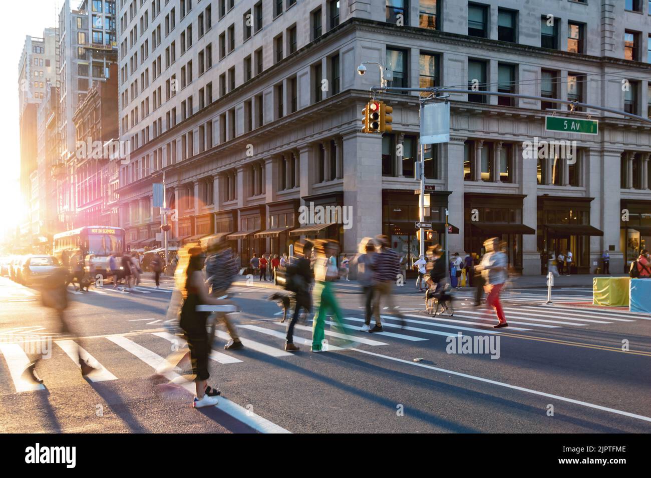 Bunte Menschenmassen, die durch die geschäftige Kreuzung an der 23. Street und 5. Avenue in New York City NYC laufen Stockfoto