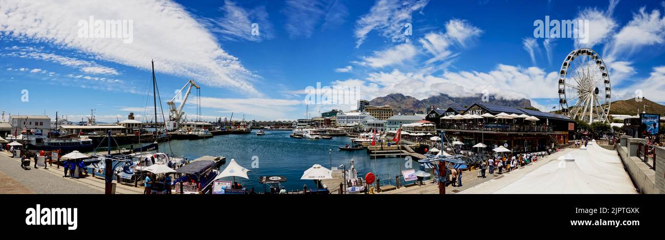 Ein Panoramablick auf die V&A Waterfront mit Tafelberg im Hintergrund mit Schiffen und Touristen Stockfoto