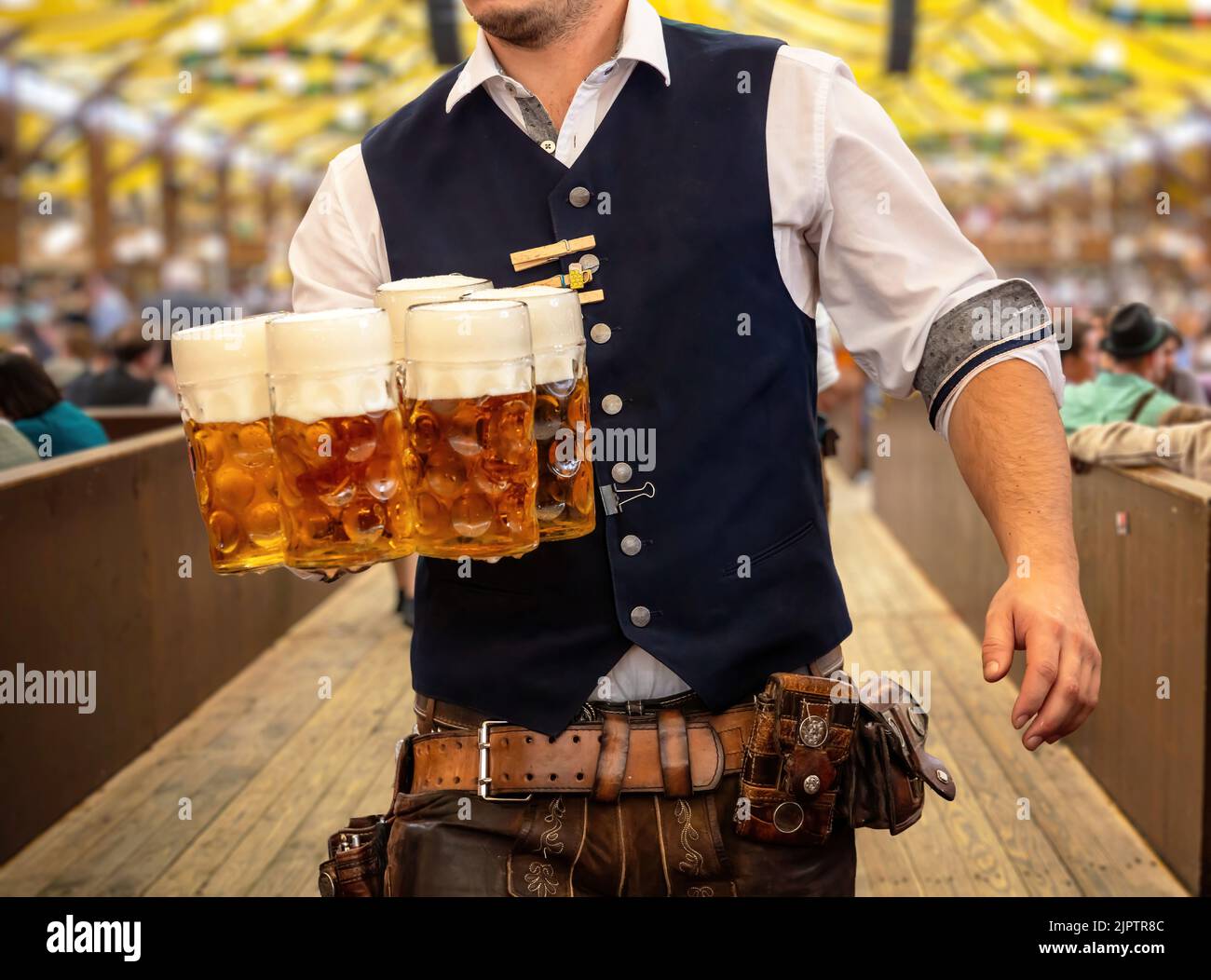 Oktoberfest, München. Kellner in traditioneller bayerischer Tracht serviert Bier, Nahaufnahme. Oktober Fest Deutsches Bierfest. Stockfoto