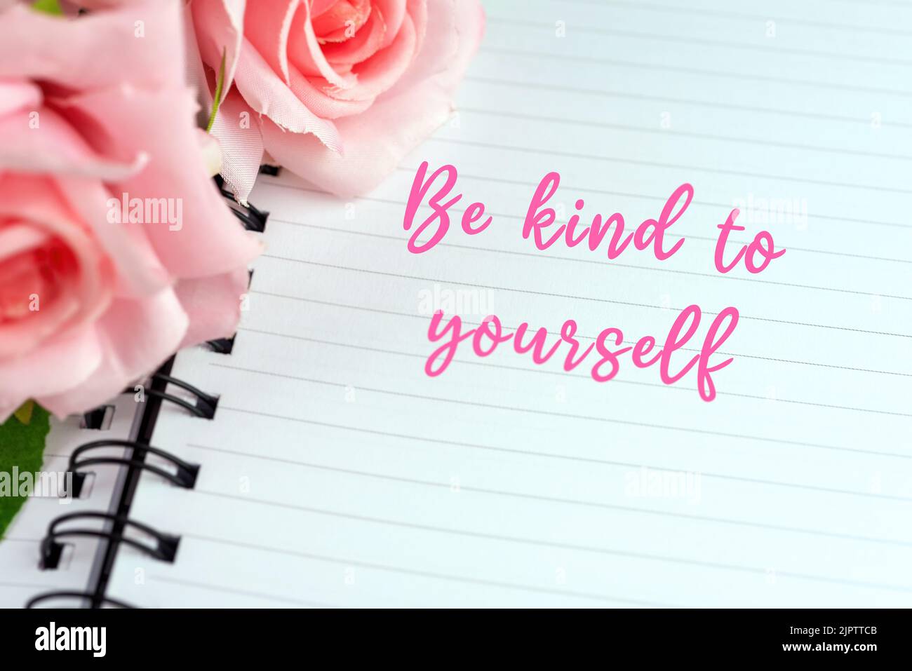 Notizblock mit inspirierendem Anführungsstext - sei gütig zu dir selbst. Stockfoto