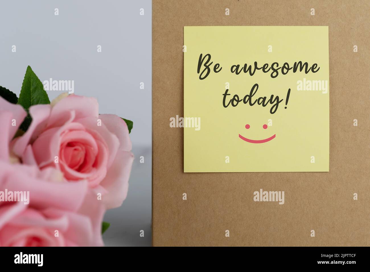 Rosa Rose und gelbe Klebenote mit inspirierenden Zitaten - sei heute großartig Stockfoto