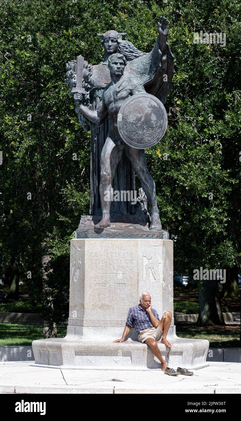 Charleston, SC - 7 2022. August: Ein alter Mann, der sich barfuß auf dem Denkmal der Confederate Defenders of Charleston entspannt Stockfoto