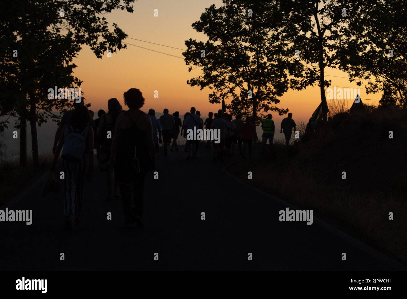 Gruppe von Silhouetten bei Sonnenuntergang von Menschen, die auf der Straße von Viznar nach Alfacar anlässlich des beliebten marsches zu Ehren von Federico gar spazieren gehen Stockfoto