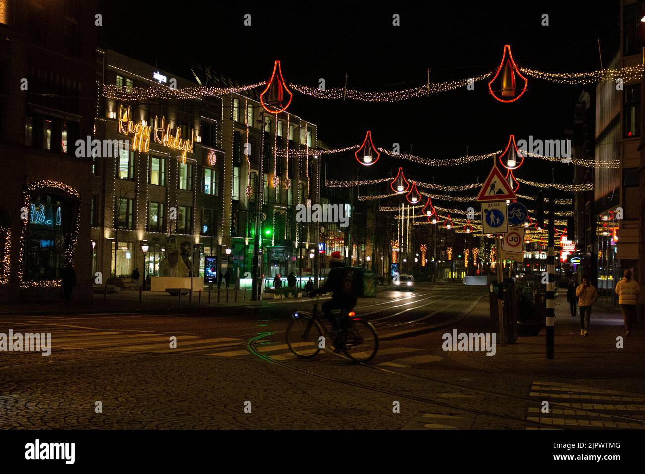 Amsterdam, Niederlande, Dezember 21. 2021. Ein Radfahrer auf einer Straße von Amsterdam in der Nacht während einer teilweisen Sperre vor Weihnachten. Stockfoto