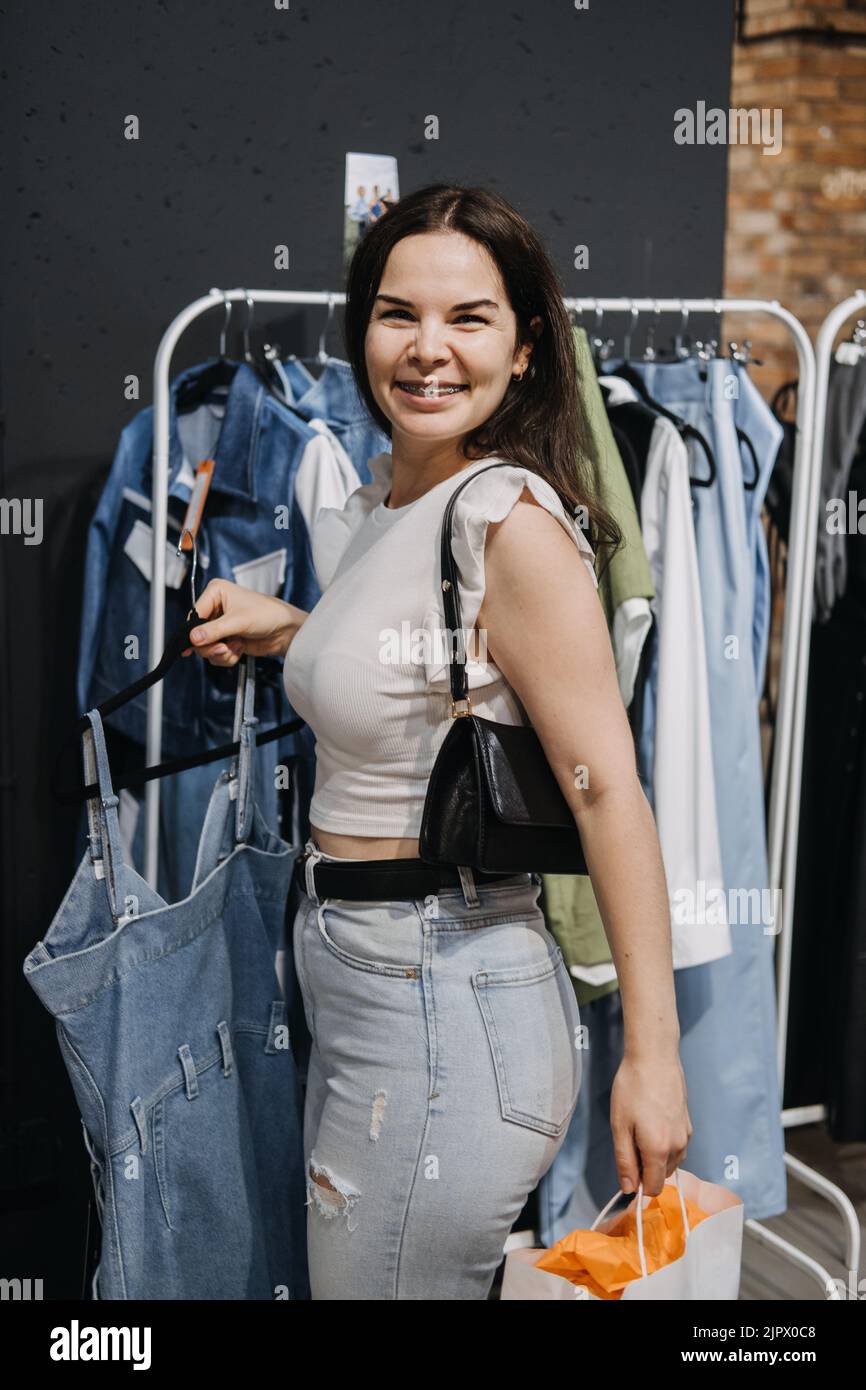 Junge Brünette Latina Attraktive Frau Shopper Wahl neue Jeans Tuch im Geschäft. Stockfoto