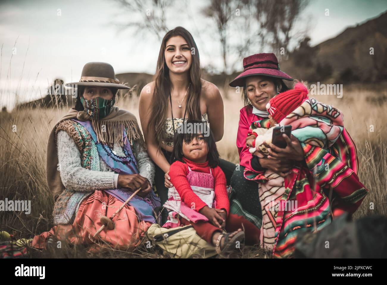 Eine Familie, die mit bolivianischen traditionellen, farbenfrohen Kostümen im Freien posiert Stockfoto