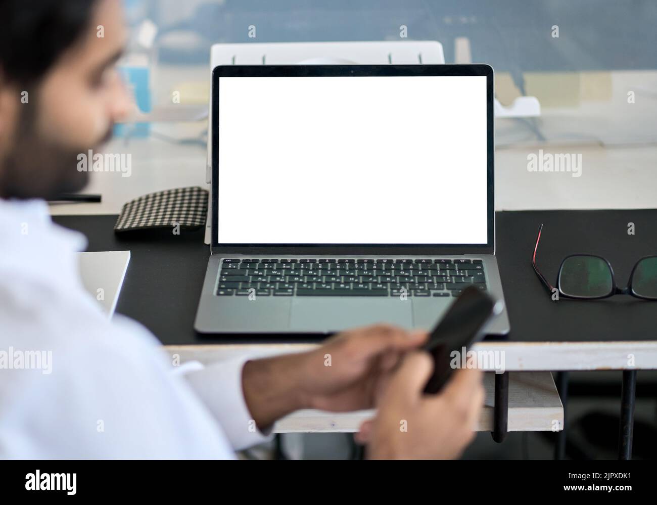 Geschäftsmann, der mit einem White-Screen-Modell für Laptops im Hintergrund arbeitet. Stockfoto