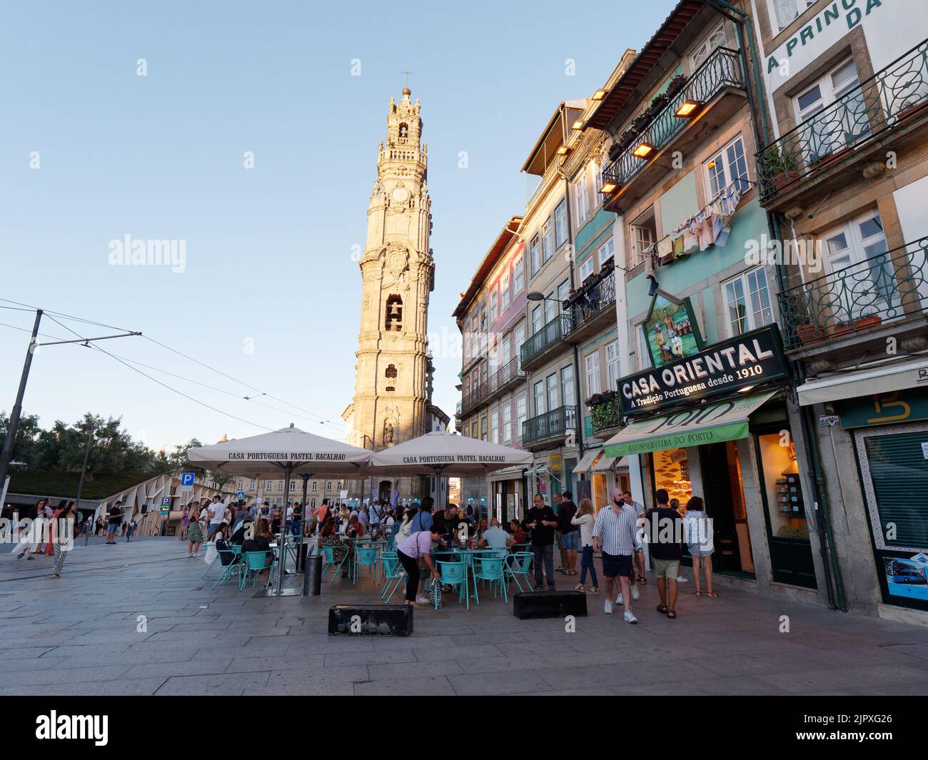 An einem Sommerabend in Porto, Portugal, speisen die Gäste in einem Restaurant mit der barocken Kirche Clérigos. Stockfoto