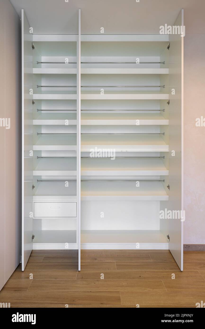 Offener weißer Kleiderschrank mit innenliegenden Regalen und im Flur Stockfoto