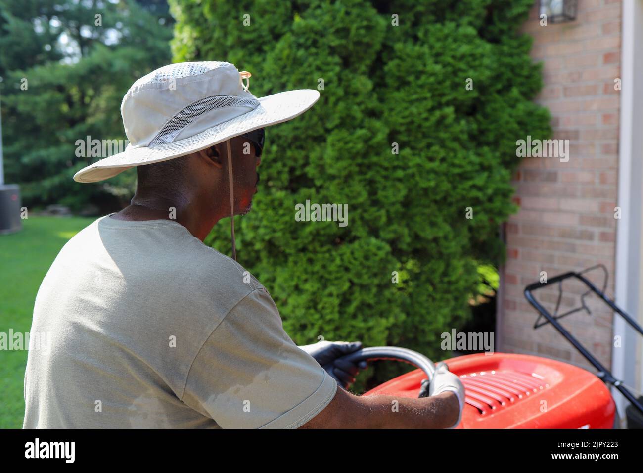 Ein Porträt eines schwarzen afroamerikanischen Mannes, der auf einem Rasenmäher reitet Stockfoto