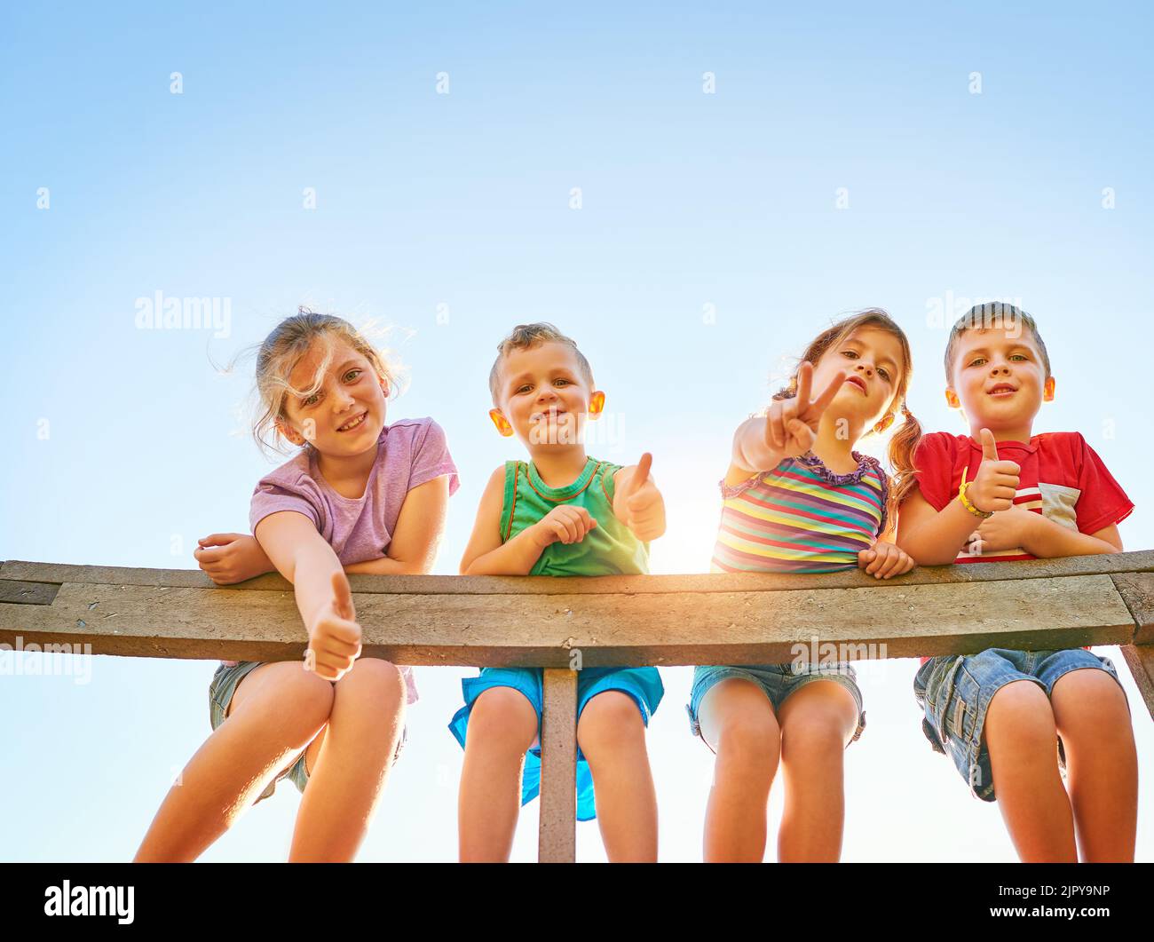 Daumen hoch für ein wenig Sommerspaß. Porträt einer Gruppe von kleinen Kindern, die Daumen hoch zeigen, während sie im Freien zusammen spielen. Stockfoto