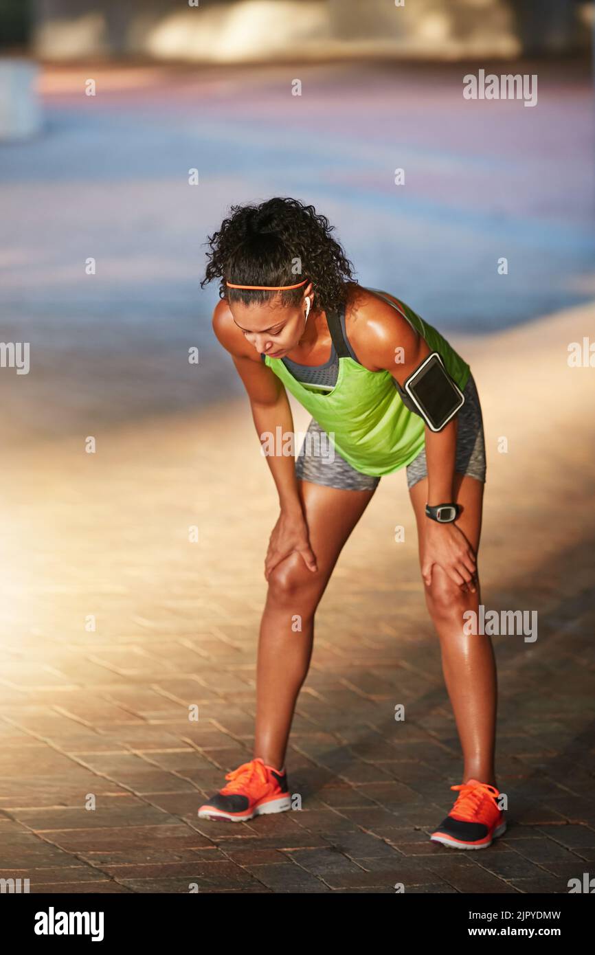 Eine sportliche junge Frau, die beim Laufen eine Pause einnimmt. Stockfoto