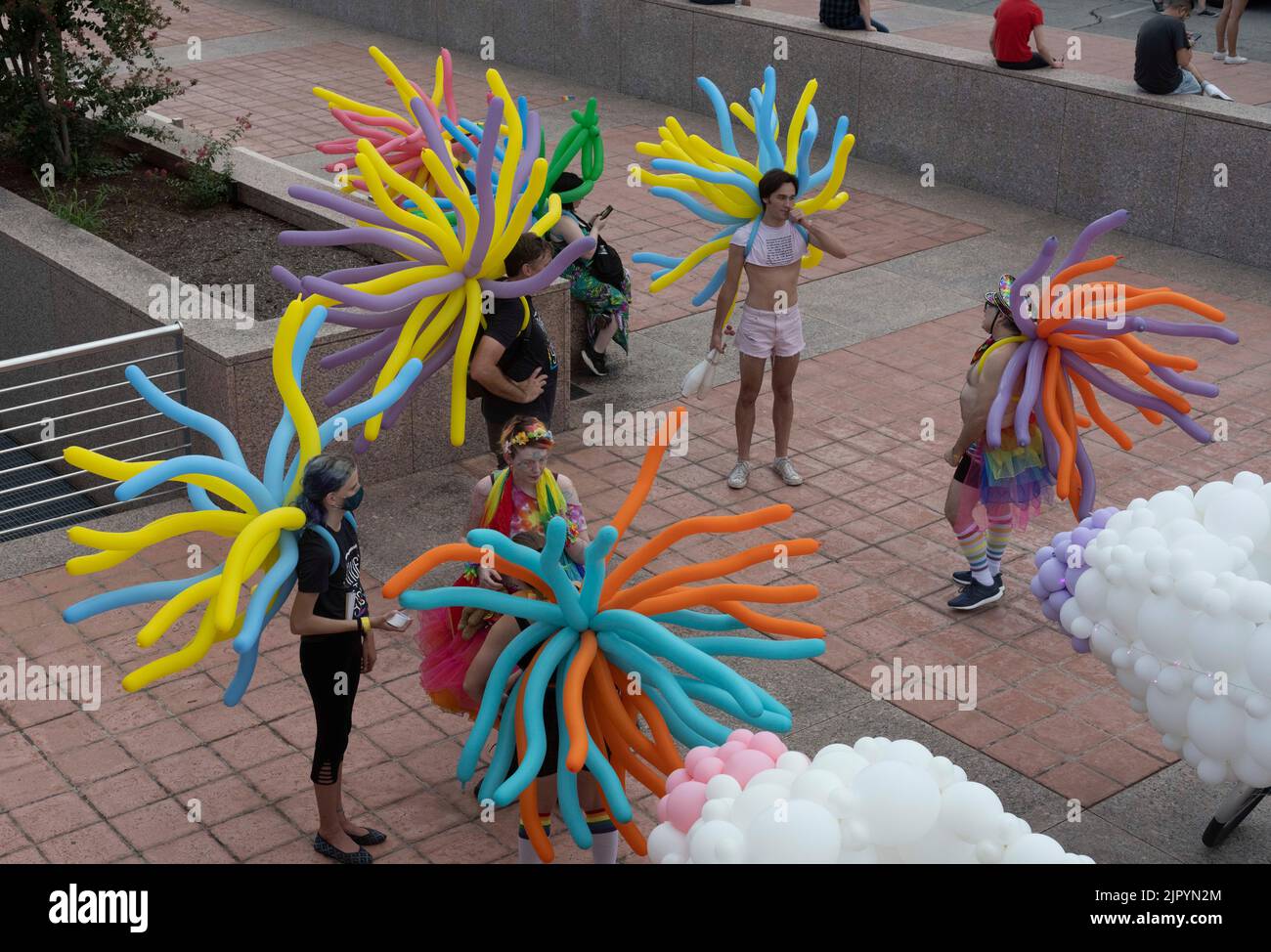 Nachtschwärmer in farbenfrohen Ballonkostümen versammeln sich im Bühnenbereich, bevor sie die Congress Avenue in der Nähe des Texas Capitol entlang fahren, während die Austin Pride Parade nach einer dreijährigen Pause aufgrund der Pandemie zurückkehrt. Die Organisatoren der LBGTQ schätzen, dass über 40.000 Menschen marschierten und an der Abendgala vom Capitol zur Congress Avenue Bridge über den Lady Bird Lake teilnahmen. Kredit: Bob Daemmrich/Alamy Live Nachrichten Stockfoto