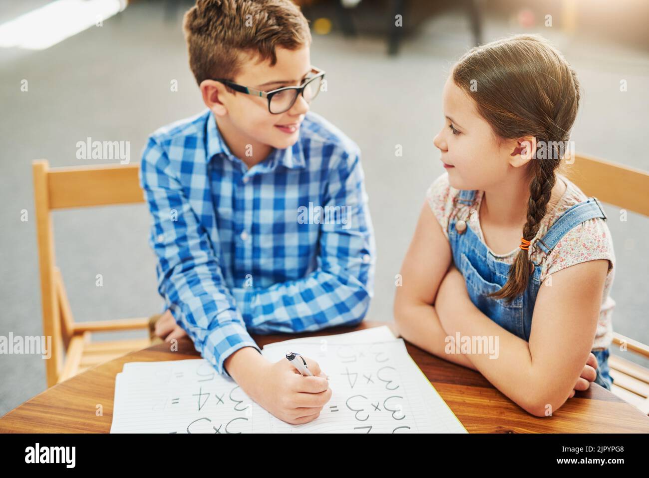 Ist das wirklich die Antwort? Zwei kleine Kinder arbeiten tagsüber in einem Klassenzimmer zusammen. Stockfoto