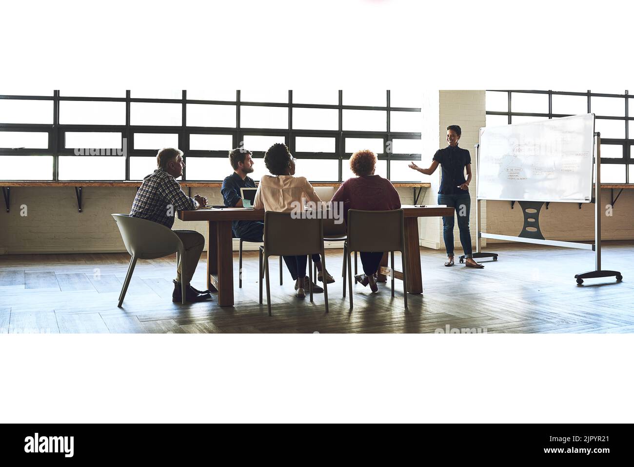 Glauben Sie an Ihre Ideen, und führen Sie sie dann aus. Eine Gruppe von Kollegen, die ein Büromeeting abhalten. Stockfoto