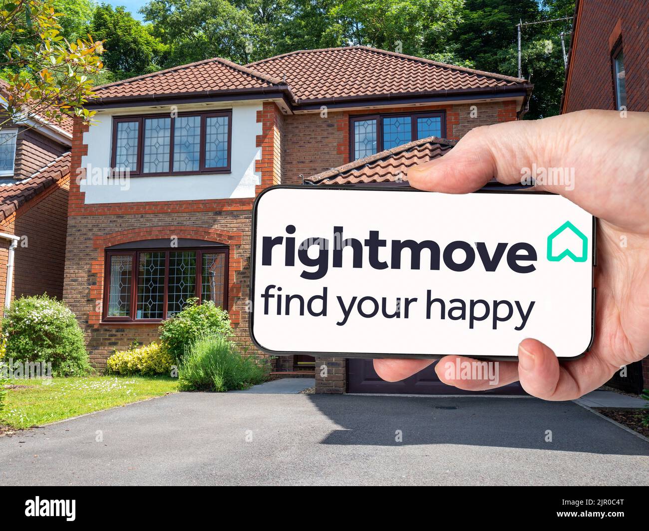 Cardiff Mid glamorgan Wales UK Person mit Mobiltelefon und Logo des britischen Immobilien-Onlineportals Rightmove plc auf dem Bildschirm vor dem Wohnsitz Stockfoto