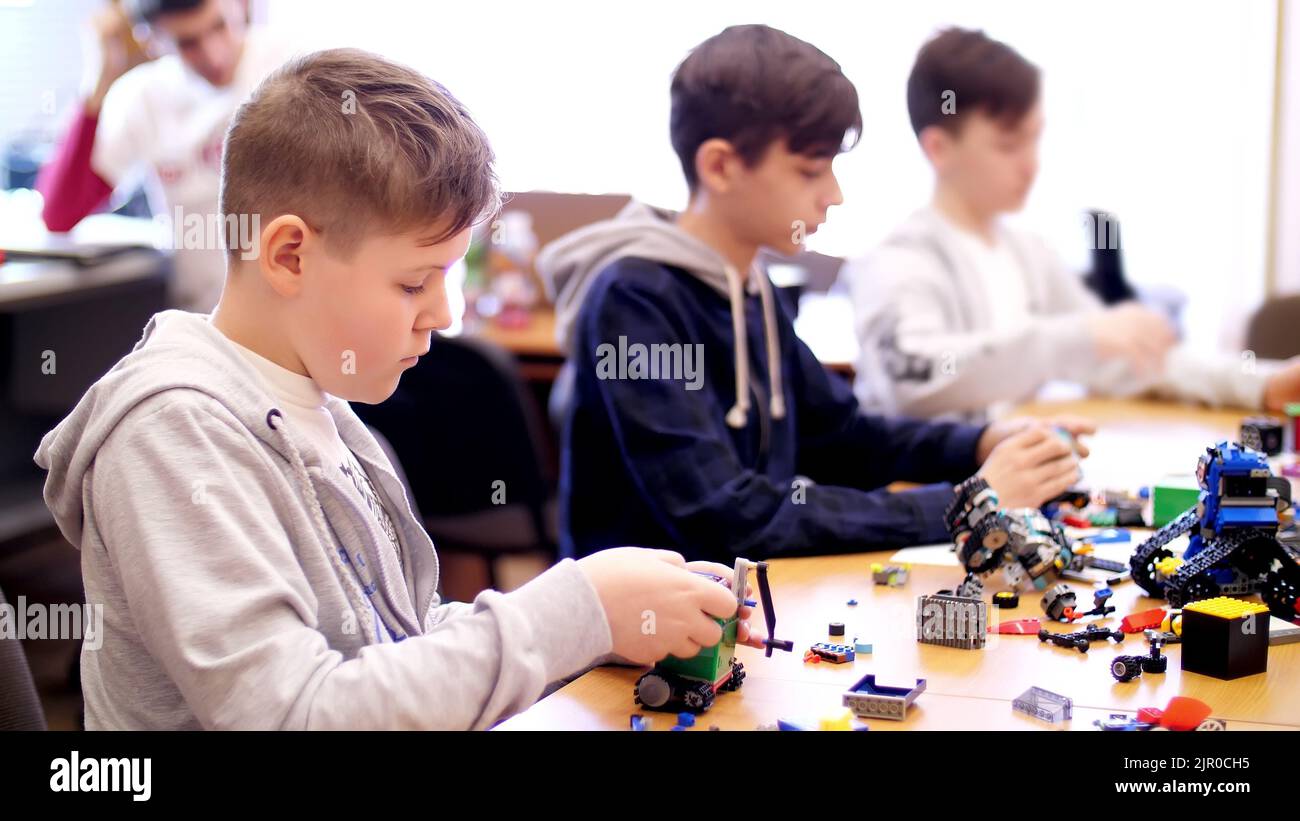 Jungs von 12 Jahren, spielen in den Designer aus Würfeln, Platten, Schaltungen, Drähte. Kleine Erfinder erstellen Roboter, Maschinen aus verschiedenen Teilen des Designers. Hochwertige Fotos Stockfoto