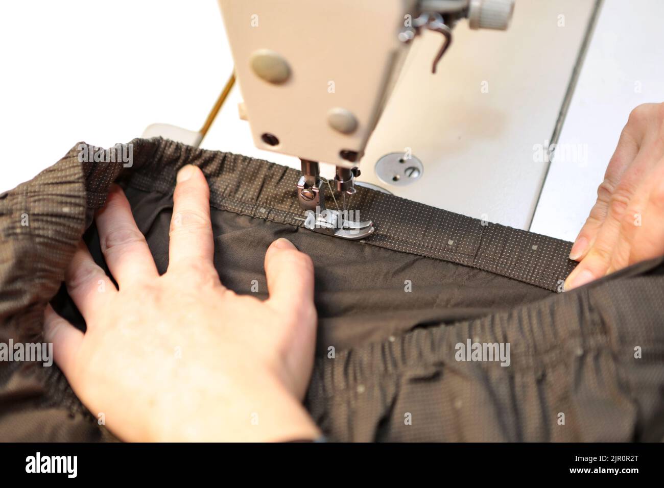 Schneiderei kaufen. Eine Frau stellt Kleidung auf einer Nähmaschine her. Modeindustrie für Menschen. Stilvolle Fashionista Frau schaffen neue Stoff-Design coll Stockfoto
