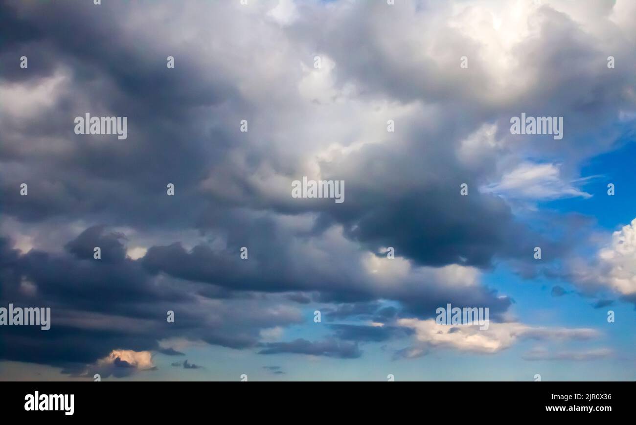 Wunderschöne dunkle, stürmische Wolken am blauen Himmel vor einem Gewitter Stockfoto