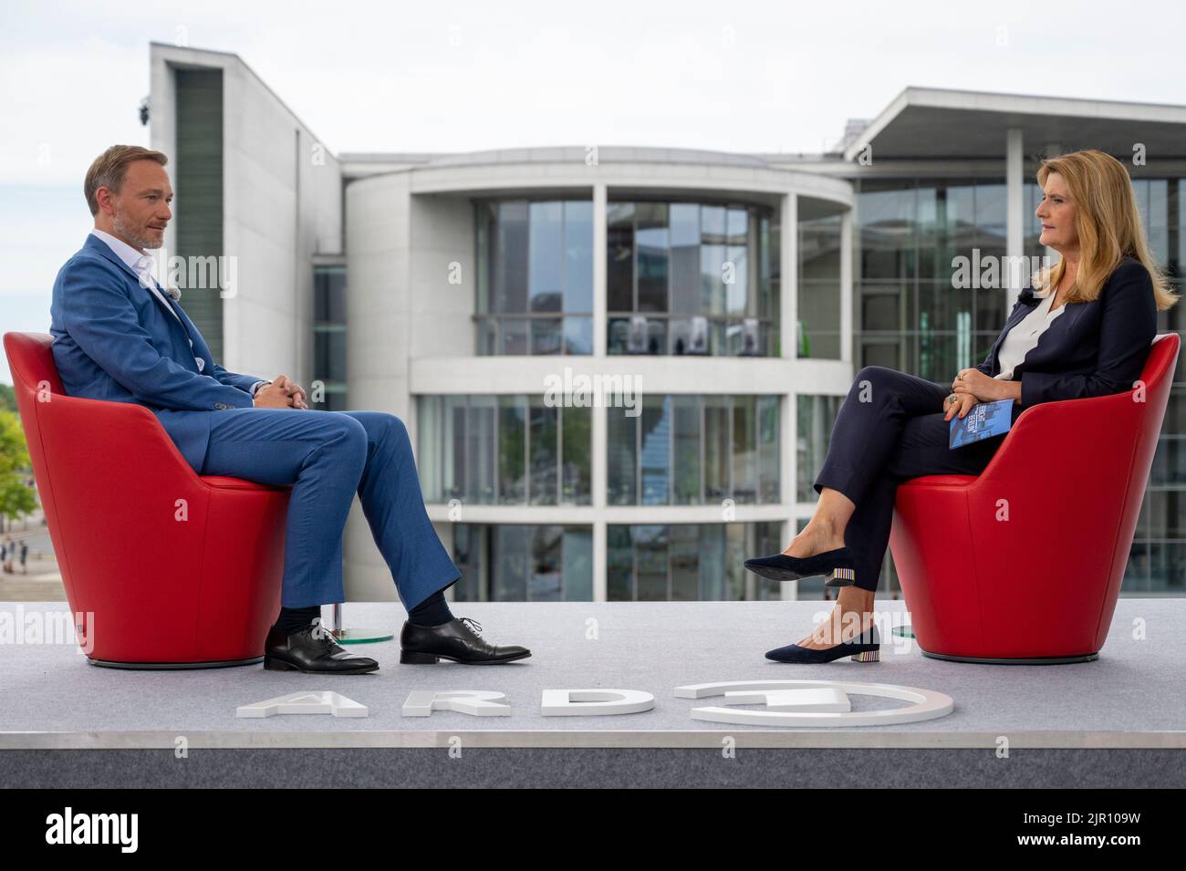 Berlin, Deutschland. 21. August 2022. Bundesfinanzminister Christian Lindner (FDP) sitzt auf der Terrasse des Marie-Elisabeth-Lüders-Hauses mit Tina Hassel, Leiterin des ARD-Hauptstadtstudios, während des Sommerinterviews des ARD-Berichts "Report from Berlin". Quelle: Christophe Gateau/dpa/Alamy Live News Stockfoto