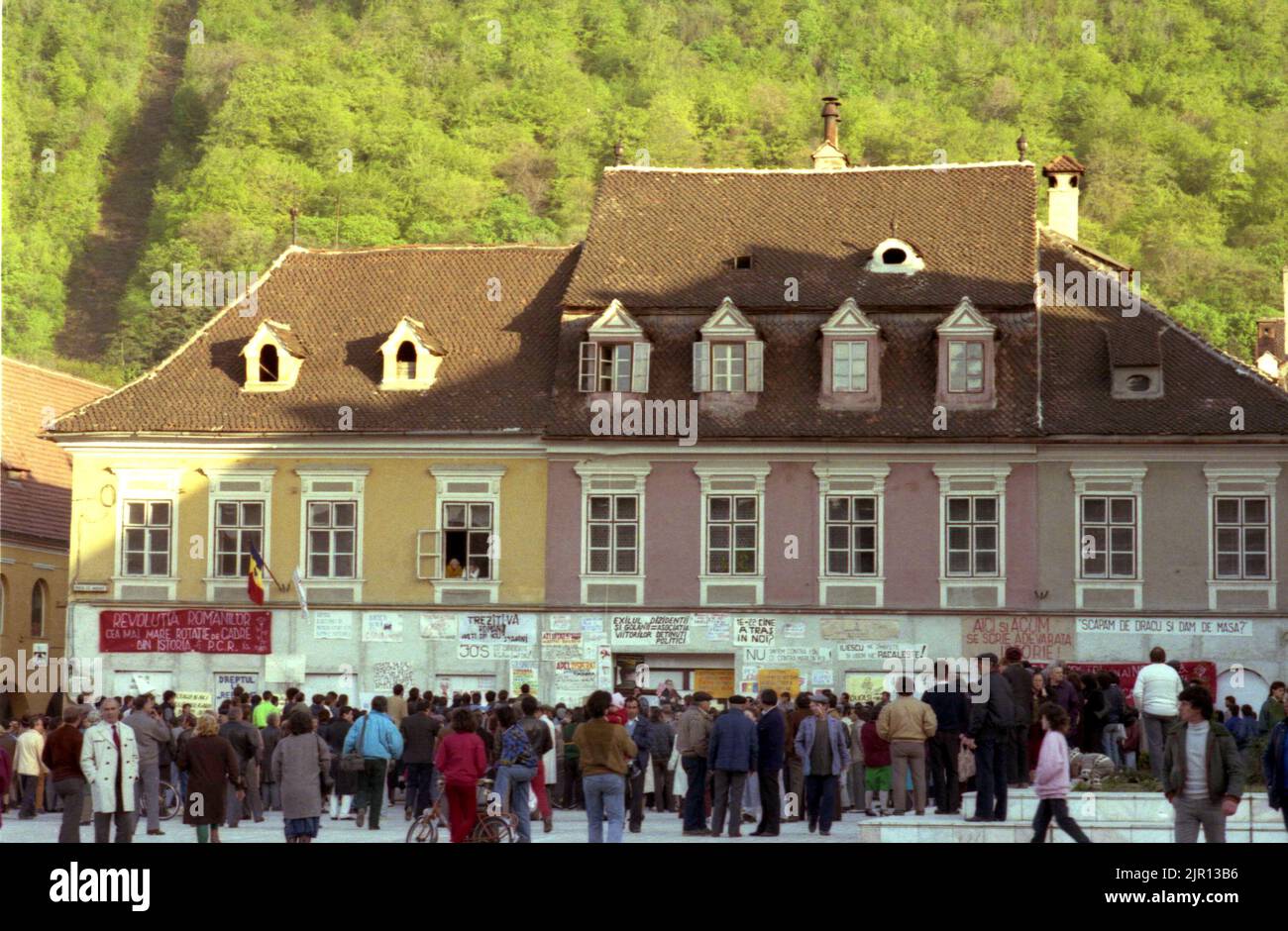 Brasov, Rumänien, April 1990. Nach der antikommunistischen Revolution von 1989 brachen im ganzen Land Proteste gegen die ehemaligen kommunistischen Beamten aus, die sofort die Macht ergriffen hatten. Auf dem zentralen Platz von Brasov lesen die Menschen Plakate und Transparente, die die neue Partei an der Macht, F.S.N., verurteilten Stockfoto