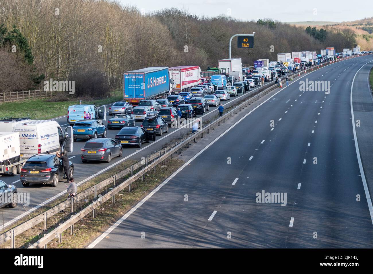 3 Stationärspuren mit Fahrern aus dem Auto neben 3 gegenüberliegenden Fahrspuren, die auf einer Autobahn aufgrund eines Notfalls leer sind Stockfoto