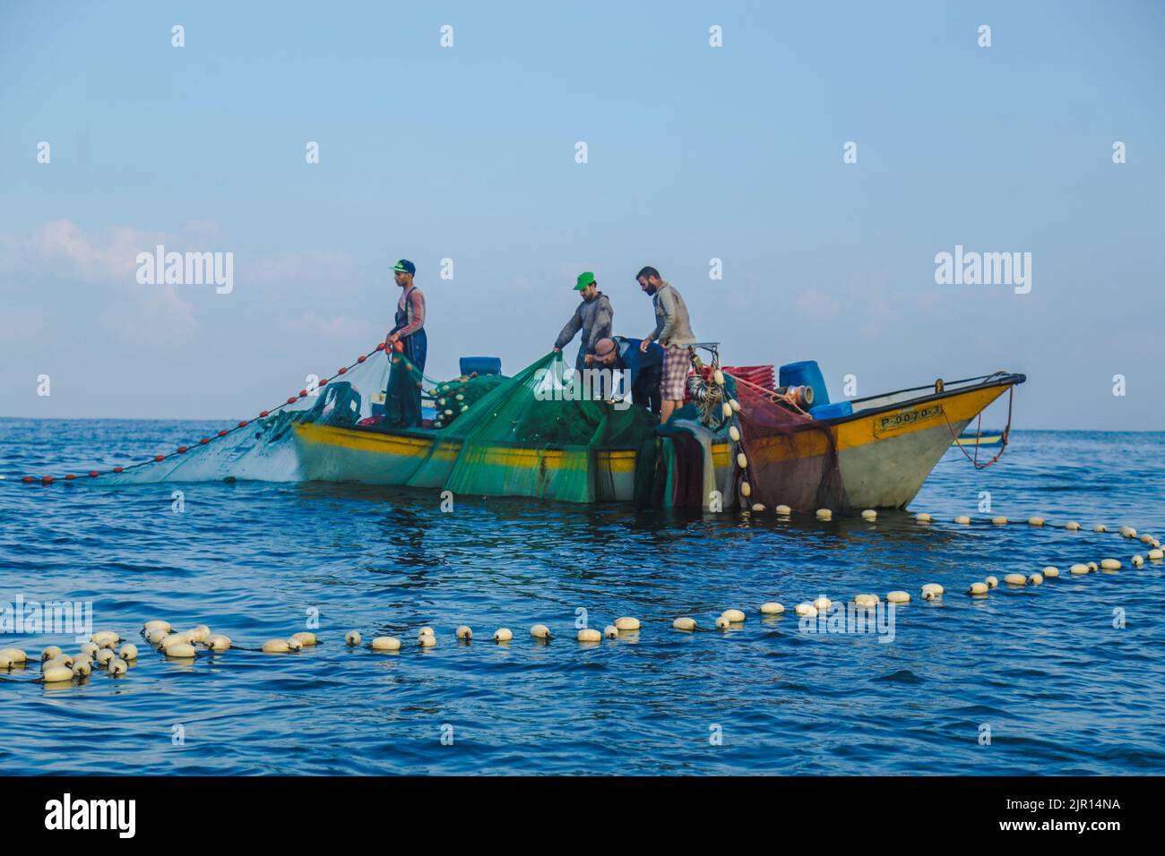 Gaza, Palästina Eine Gruppe von Fischern, die im offenen Meer von ​​Gaza zahlreiche Fischernetze mit Fischen sammeln Stockfoto