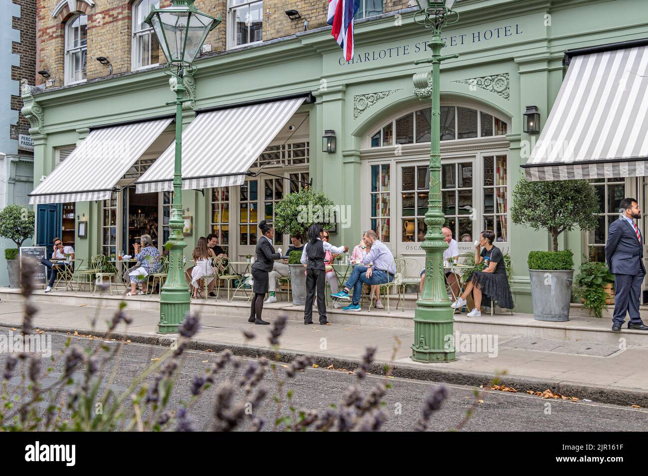 Menschen, die am Eingang des Charlotte Street Hotels in der Charlotte Street, Fitzrovia, London W1, vorbeigehen Stockfoto