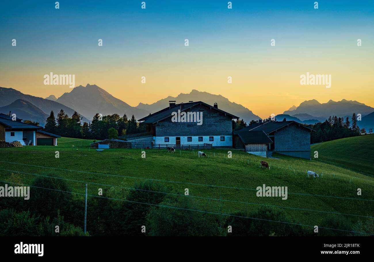 Traditioneller Bauernhof in der Nähe von Krispl in Österreich, mit klarem Himmel und deutschen Alpen in der Ferne Stockfoto