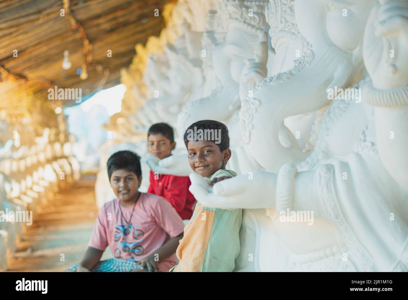Pileru, Indien - Juli 28,2022:Junge Kinder saßen auf den ganesha-Idolen.Schwarzer Hautjunge vorne im Fokus. Stockfoto