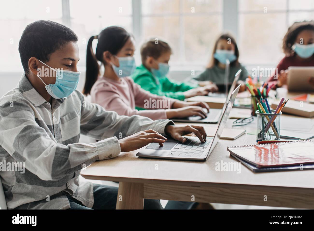 Schwarz Schoolboy Mit Laptop Mit Klasse Im Modernen Klassenzimmer Stockfoto