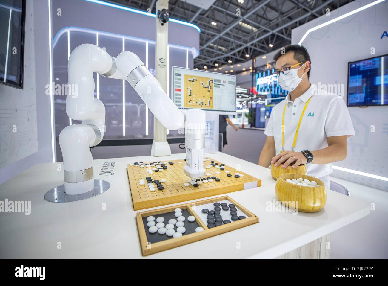 Chongqing. 21. August 2022. Ein Mitarbeiter spielt das chinesische Brettspiel Go (Weiqi) mit einem Roboter am Veranstaltungsort der Smart China Expo 2022 im südwestchinesischen Chongqing, 21. August 2022. Die Smart China Expo 2022 wird vom 22. Bis 24. August online und offline stattfinden. Quelle: Huang Wei/Xinhua/Alamy Live News Stockfoto