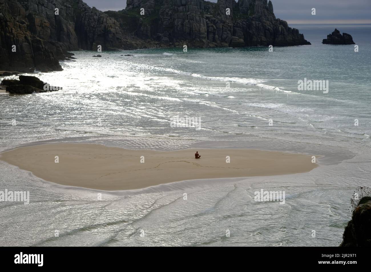 Pedn Vounder Beach in Cornwall, zwischen den Klippen von Treryn Dinas gelegen, mit kristallklarem, türkisfarbenem Wasser und einem wunderschönen weißen Sandstrand Stockfoto