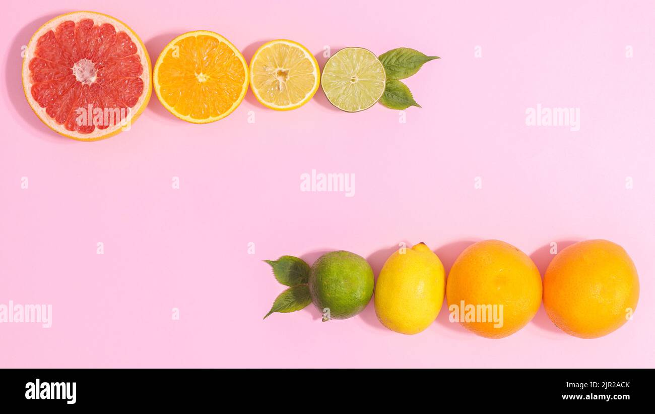 Layout der Zitrusfrüchte auf pastellrosa Hintergrund mit Kopierfläche. Flach liegend Stockfoto