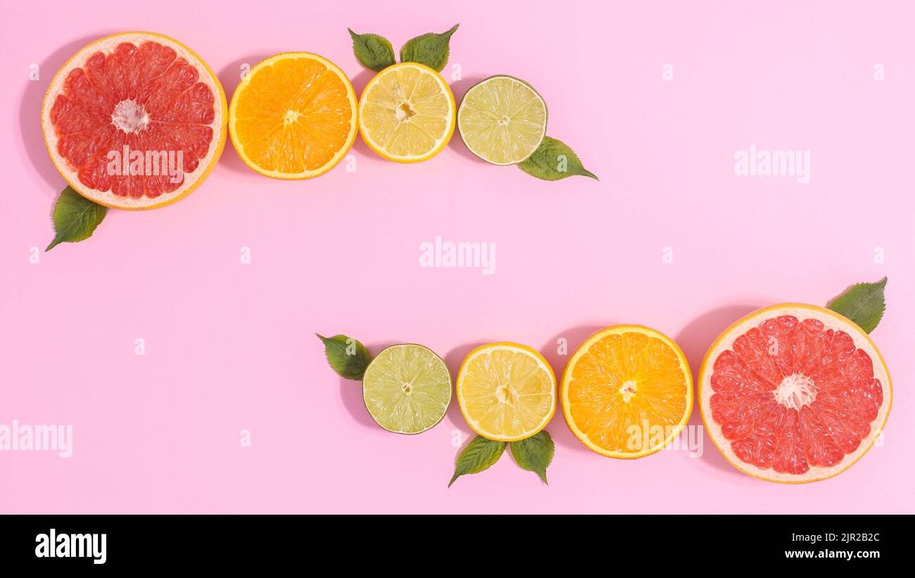 Layout der Zitrusfrüchte auf pastellrosa Hintergrund. Flach liegend Stockfoto