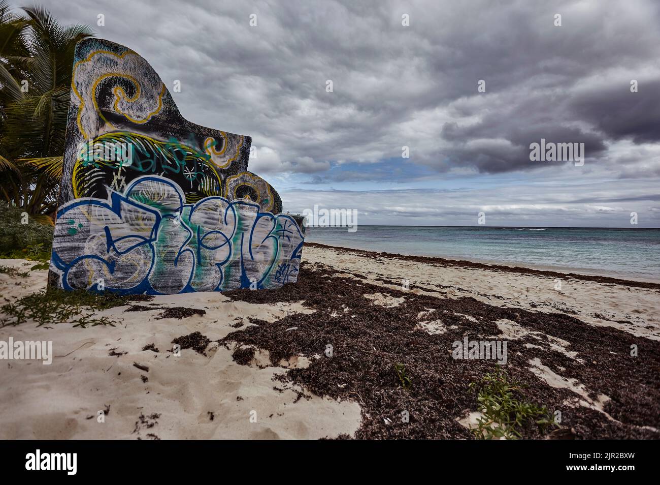 Betonblock mit Graffiti am Strand Xpu-Ha in Mexiko. Stockfoto