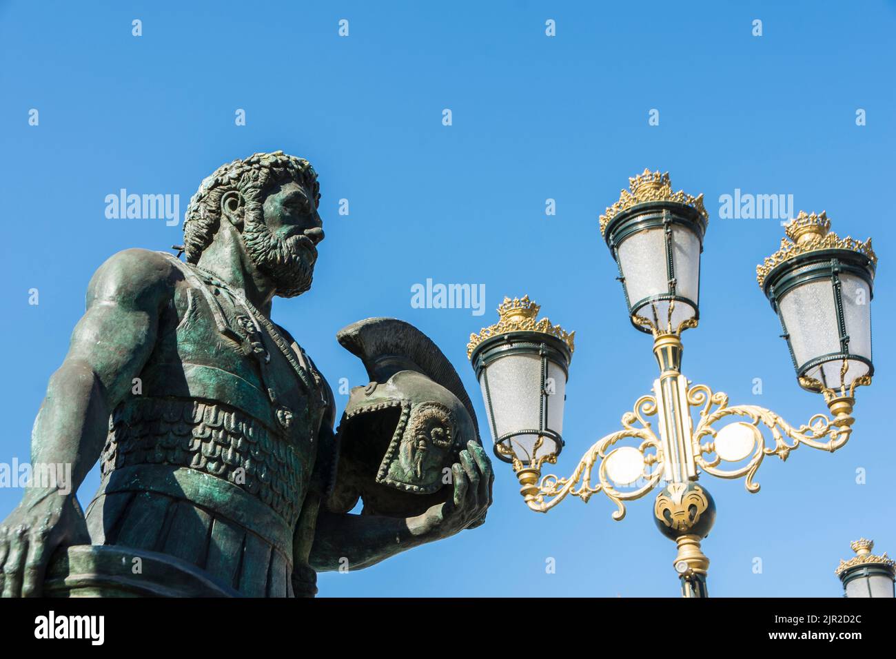 Eine Statue eines mazedonischen Kriegers und eine Straßenlaterne, eine der vielen auf der Augenbrücke in Skopje, Nord-Mazedonien Stockfoto